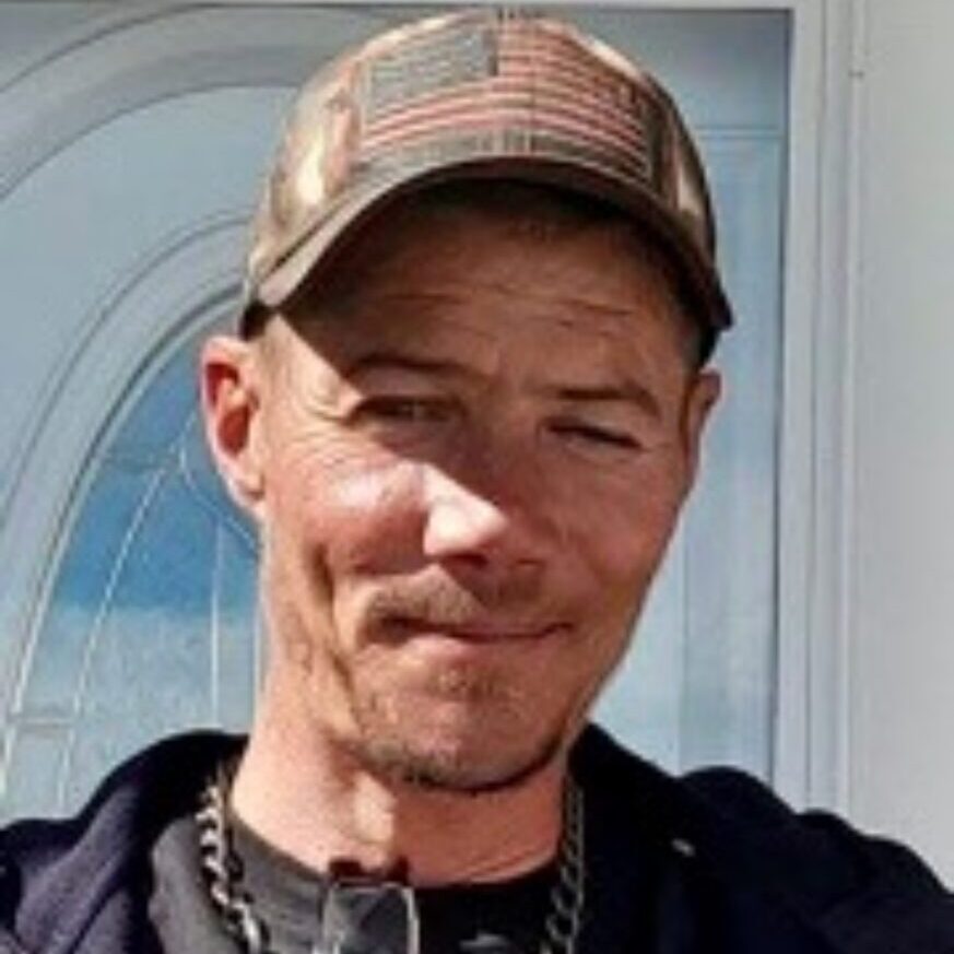 Man wearing a cap with flag design.